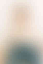 First birthday milestone photos of a baby boy in a ‘one’ sweater riding a toy race car at a studio s