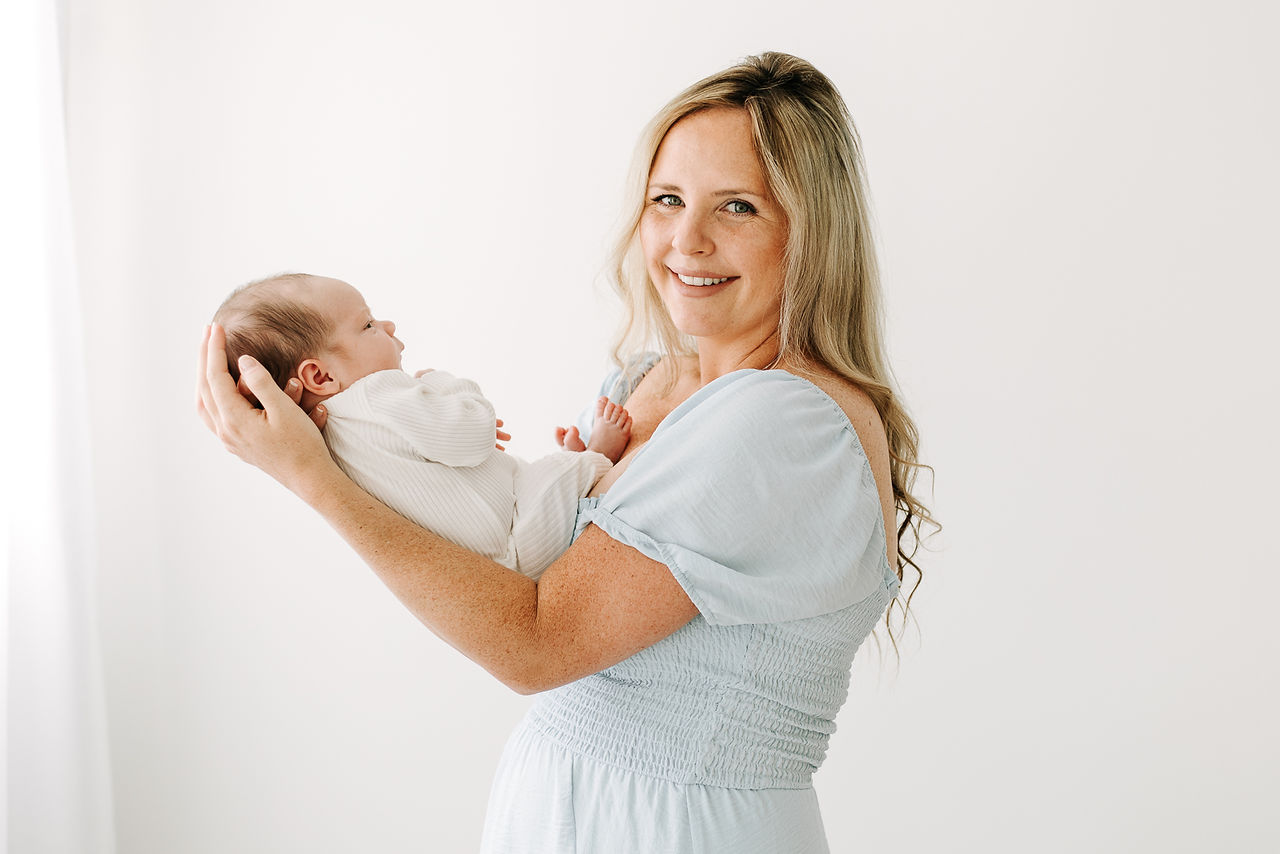 Mother and newborn baby portrait during a studio newborn session in Guelph, Ontario featuring a clean white backdrop and timeless family photography