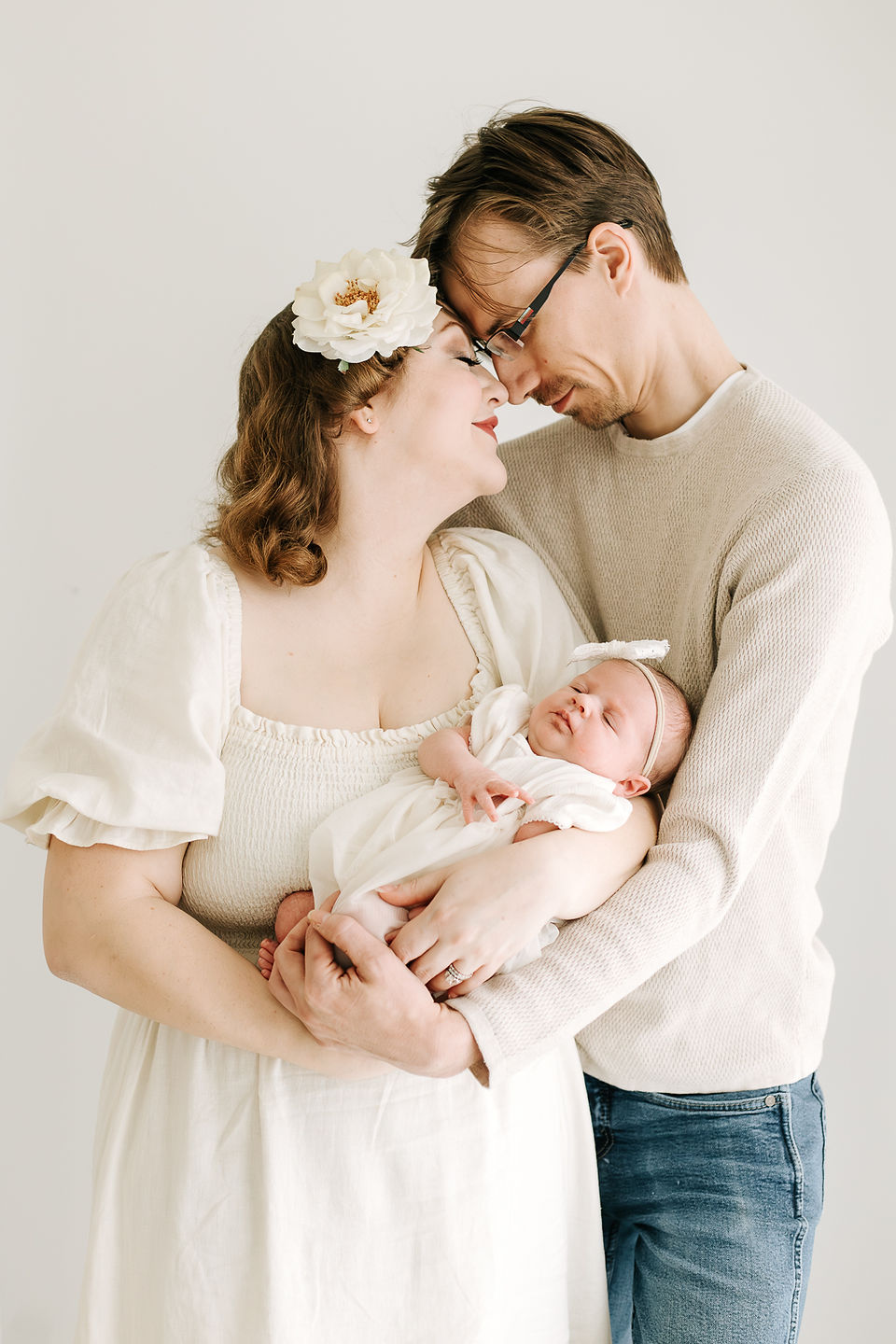 Mom and dad with newborn baby during a newborn session in Guelph, Ontario captured in a soft studio portrait