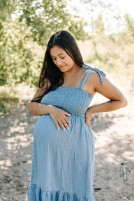 Maternity session in Guelph, Ontario featuring a timeless portrait of an expecting mother with her hand resting on her baby bump