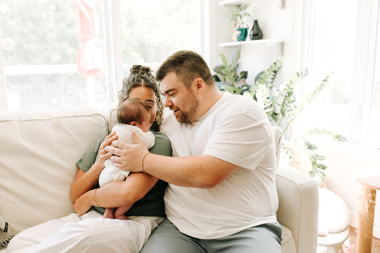 Newborn family session in Guelph, Ontario capturing parents sharing a quiet moment with their baby in their home