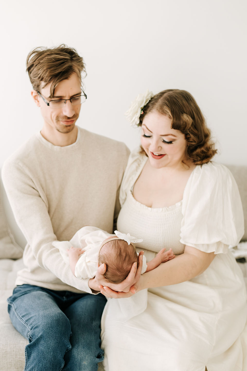 Mom and dad with newborn baby during a newborn session in Guelph, Ontario captured in a soft studio portrait
