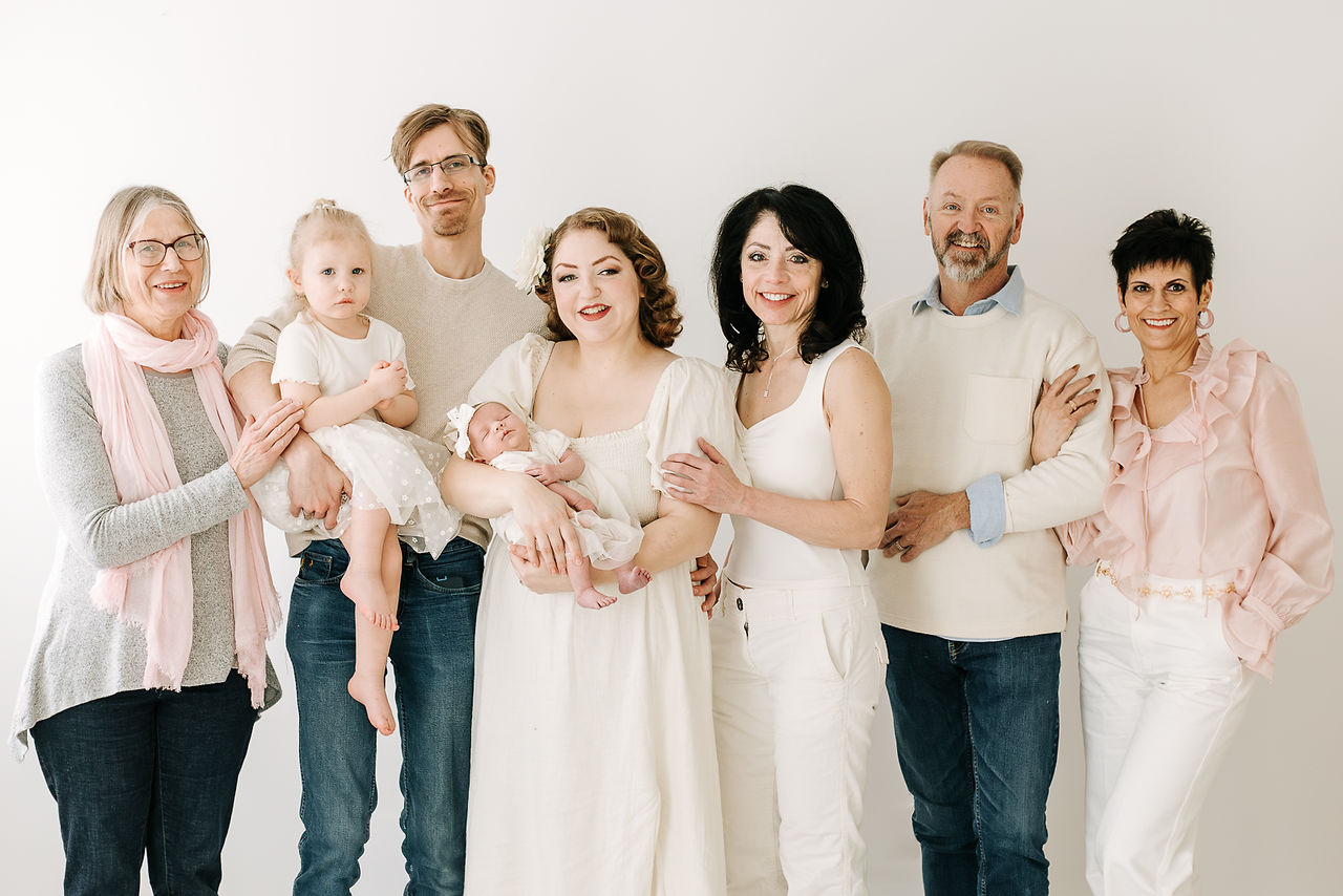 Extended family portrait during a newborn session in Guelph, Ontario with three generations including grandparents, parents, toddler, and newborn baby
