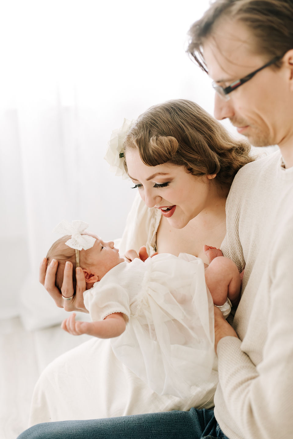 Mom and dad with newborn baby during a newborn session in Guelph, Ontario captured in a soft studio portrait