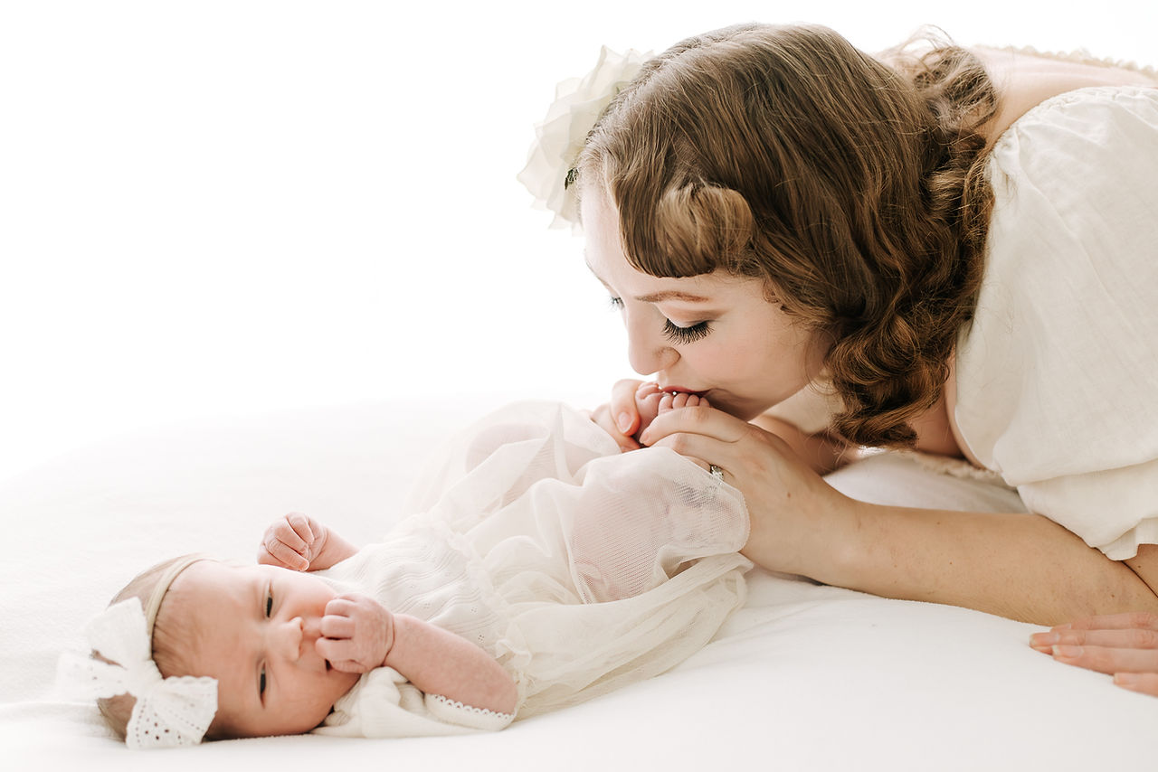 Mother with newborn baby during a newborn session in Guelph, Ontario captured in a clean, timeless style