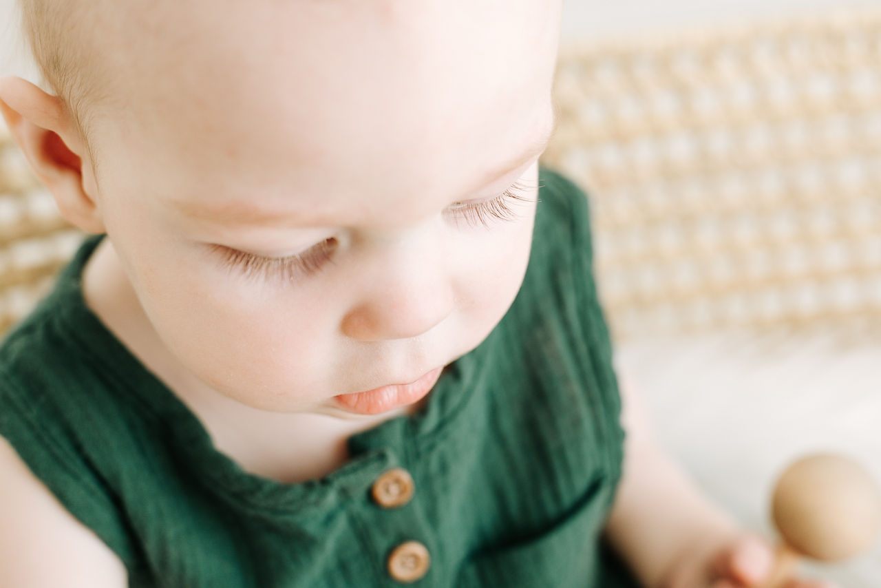 Studio portrait of a child in woven basket during a milestone session in Guelph, Ontario with soft natural lighting and simple styling