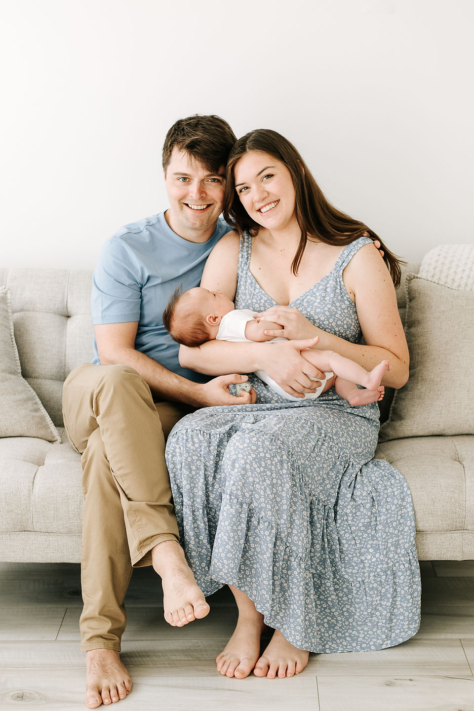 Studio newborn session in Guelph, Ontario capturing parents and newborn baby in coordinated outfits against a clean white background