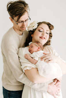 Mom and dad with newborn baby during a newborn session in Guelph, Ontario captured in a soft studio portrait