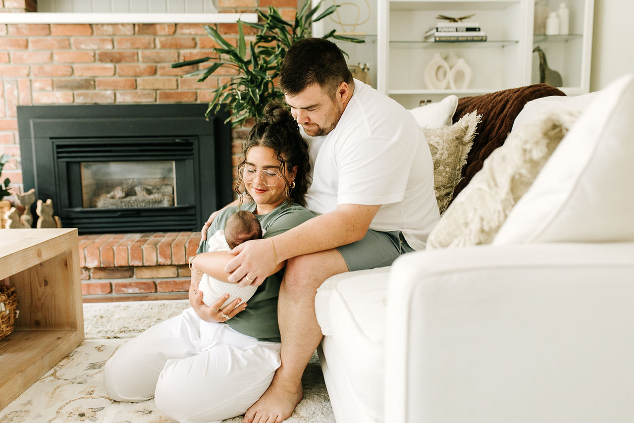 Guelph, Ontario newborn photography capturing a loving family portrait of parents holding their newborn together at home