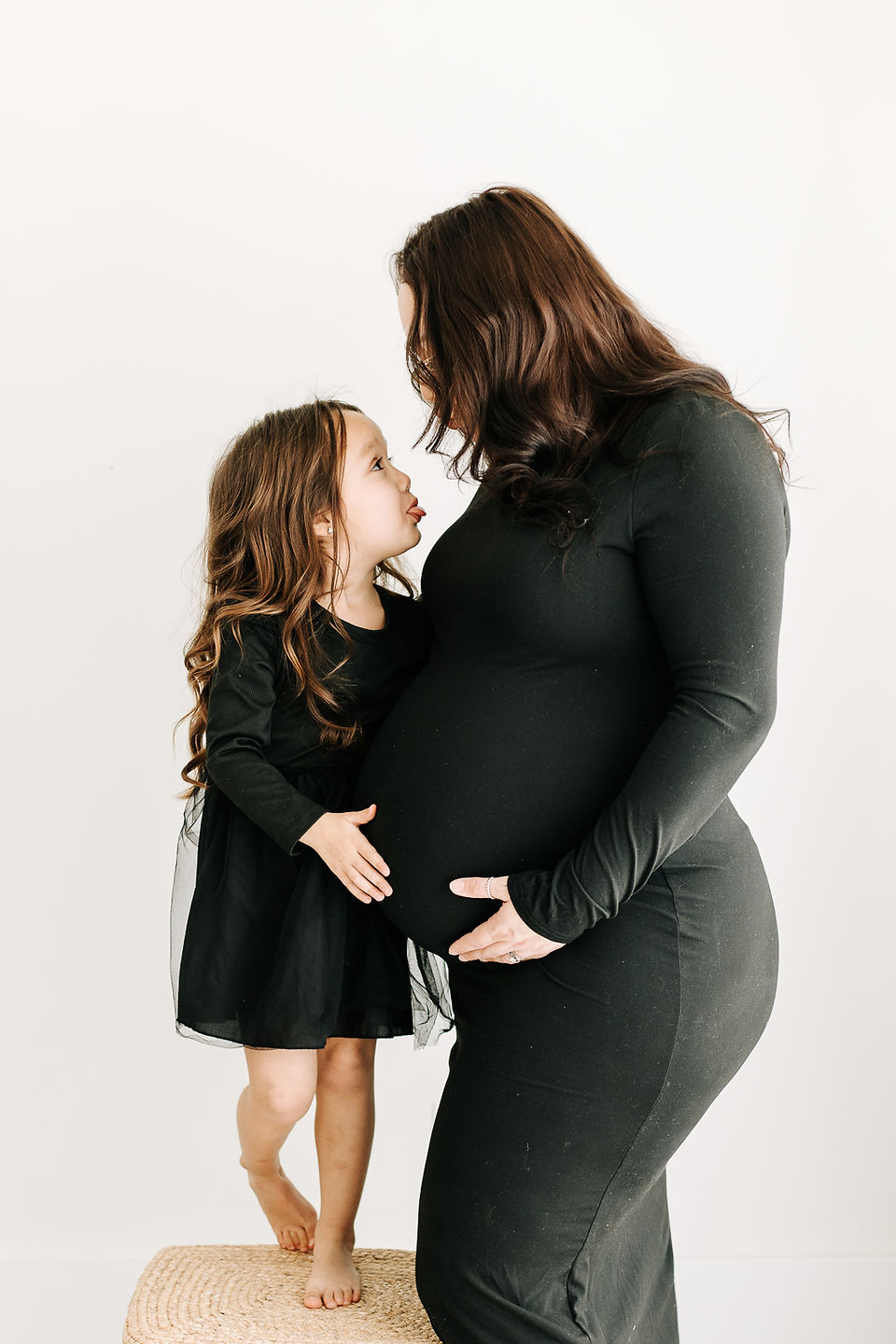 Studio maternity session in Guelph, Ontario featuring mom and her daughter in coordinated outfits, celebrating their upcoming addition.