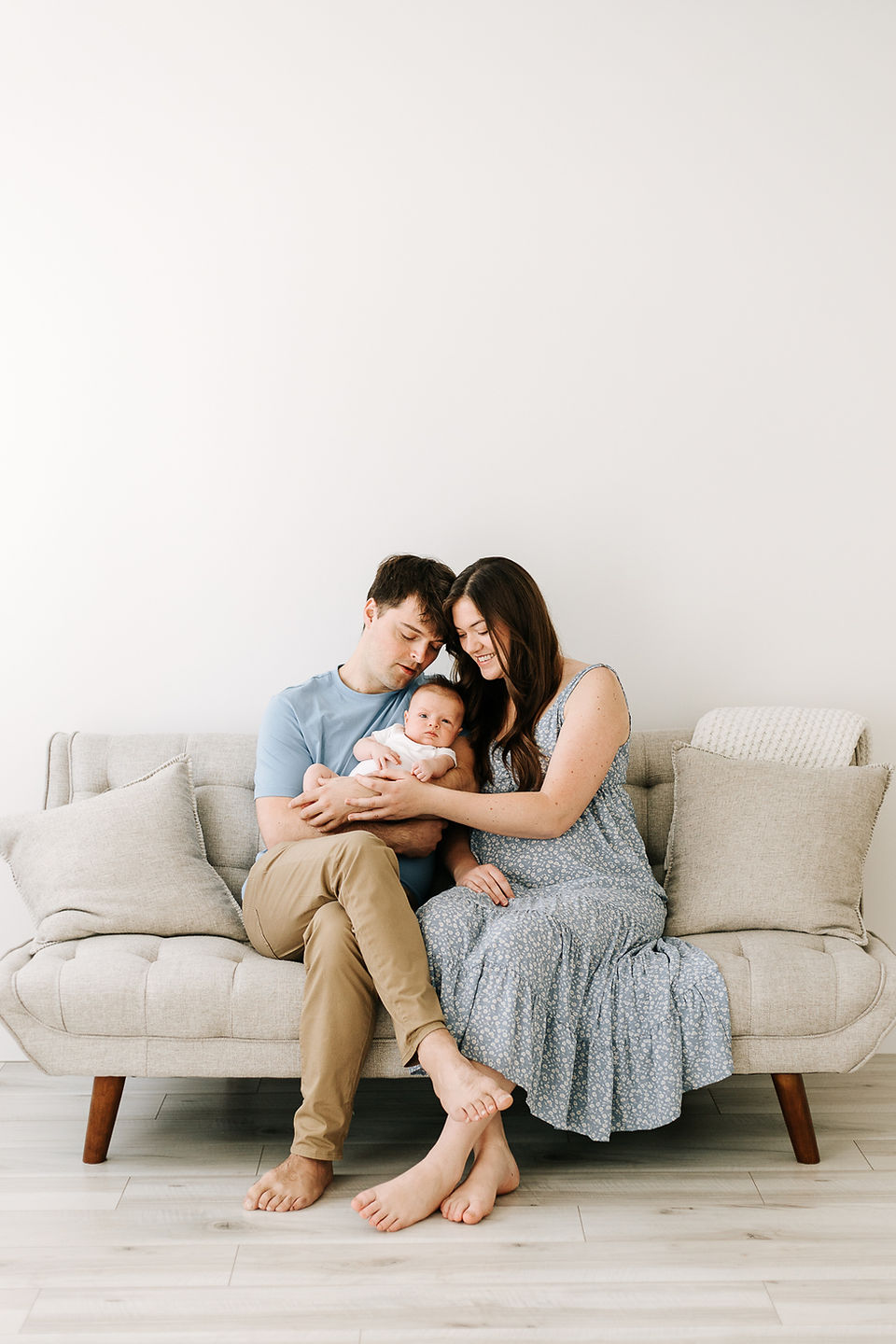 Studio newborn session in Guelph, Ontario featuring parents with their newborn baby in a bright, minimalist family portrait
