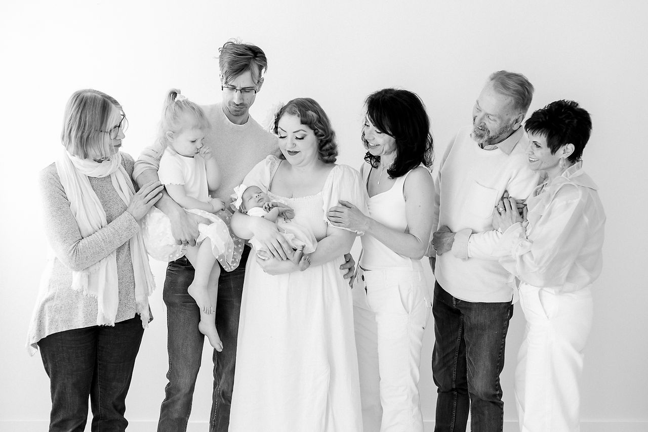 Extended family portrait during a newborn session in Guelph, Ontario with three generations including grandparents, parents, toddler, and newborn baby