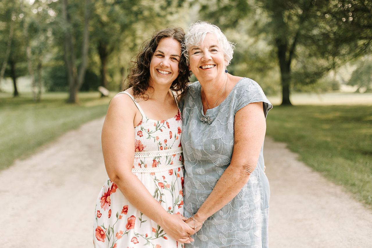 Mother and daughter smiling together during a summer family photography session at The Guelph Arboretum in Guelph, Ontario.