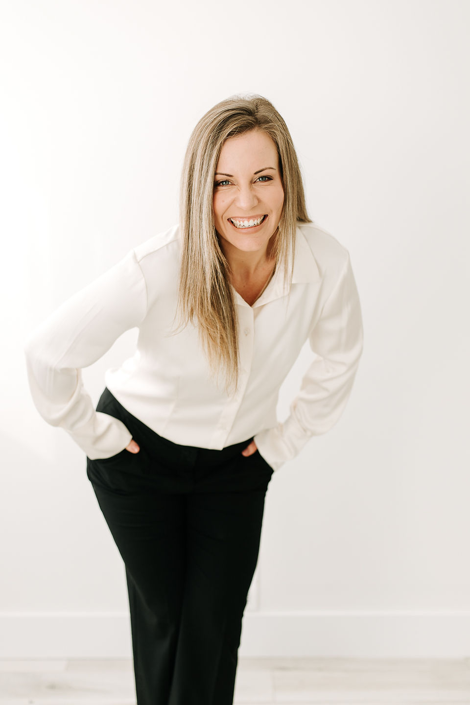 Woman in white button-down shirt and black pants posing confidently for a personal branding session in Guelph, Ontario.