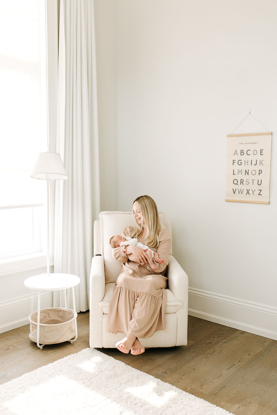 Mother holding newborn baby in a bedroom during an in-home newborn session in Guelph, Ontario