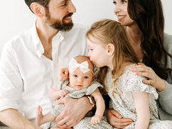 Mom and dad with newborn baby and older daughter, big sister kissing baby’s head during a newborn session in Guelph, Ontario