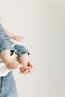 3 month baby milestone session in Guelph, Ontario featuring a timeless close-up of baby's feet and a parent's loving hands
