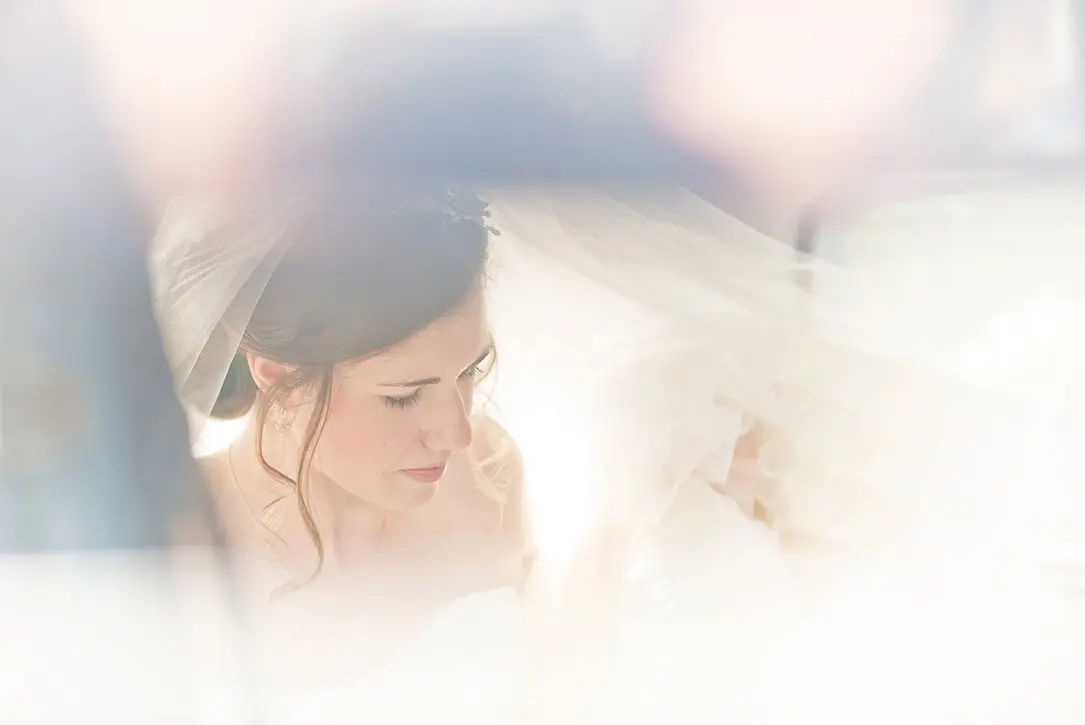 Softly lit portrait of the bride arriving at the Church in central Hereford, photographed through the bridal car window