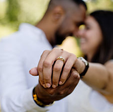 Smiling couple holding hands showing the engagement ring
