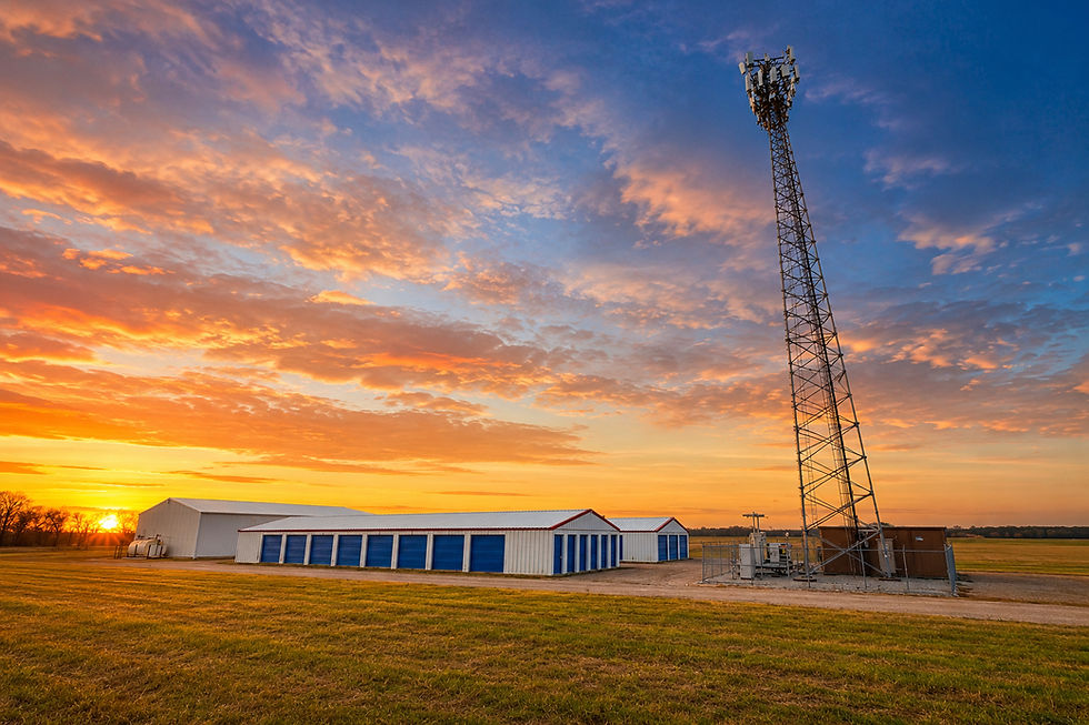 Wide landscape photo of High Tower Storage self-storage buildings and a tall tower at sunrise
