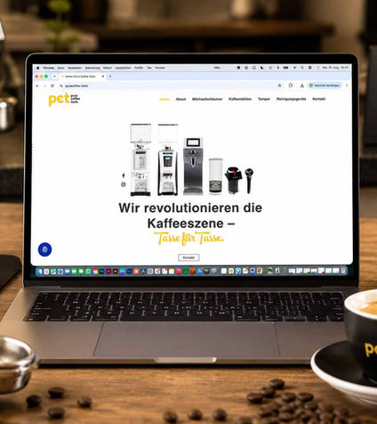 Laptop zeigt PCT-Webseite neben Kaffee und Zubehör.