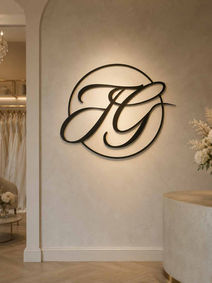 Beleuchtetes JG-Logo an einer Wand im Salon