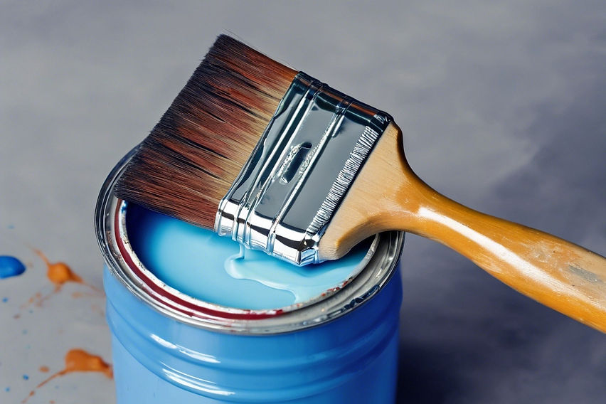 paint brush setting next to a paint can with blue paint in it_edited.jpg