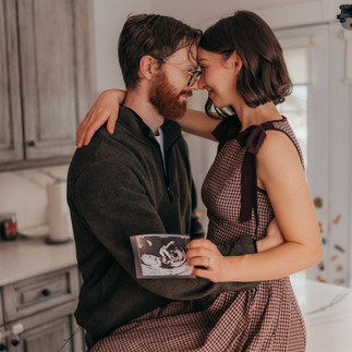 Couple pregnancy announcement in kitchen on counter holding ultrasound