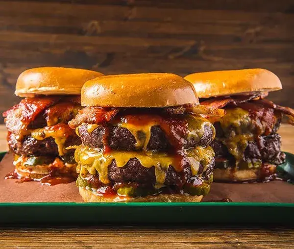 Double cheeseburgers with bacon on buns cooked on a Traeger grill
