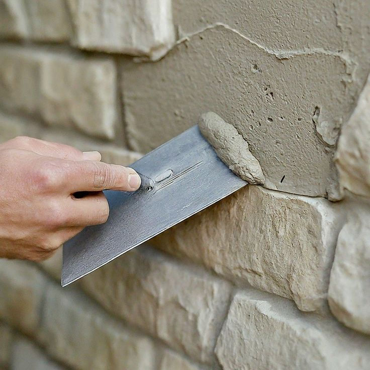 Masonry and maintenance category: mason spreading mortar with a trowel on
stone