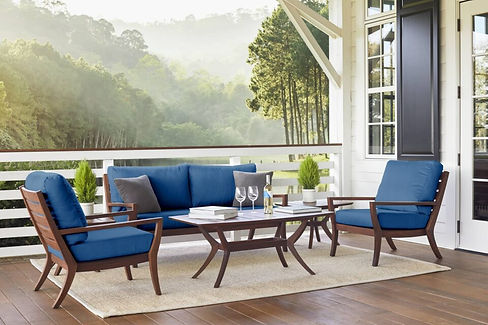 Jensen Outdoor Laguna Collection Ipe wood sofa and coffee table with dark blue Sunbrella cushions, arranged on an outdoor porch setting.