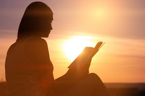 silhouette-young-beautiful-woman-dawn-sitting-ground-carefully-staring-open-book_135932-53