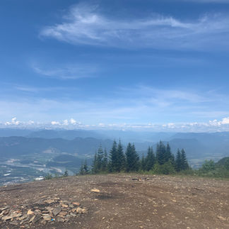 View from Upper Bridal Falls with firepit and snow-capped mountains in the distance.