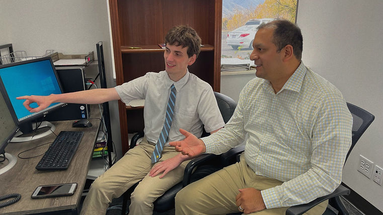 Counselor showing an ESL student information on a computer in their office