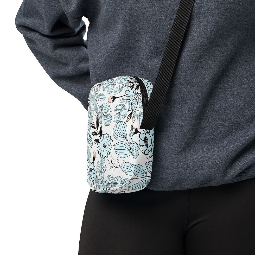 Thumbnail: White crossbody sling bag with a light blue floral pattern featuring daisies, delicate leaves, and black botanical line art.