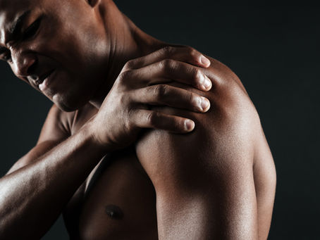 Homme ressentant une douleur à l’épaule et tenant son épaule avec sa main.