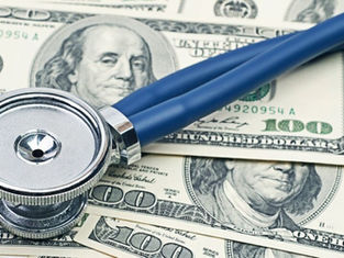 Blue stethoscope lying on U.S. $100 bills, symbolizing healthcare costs and money