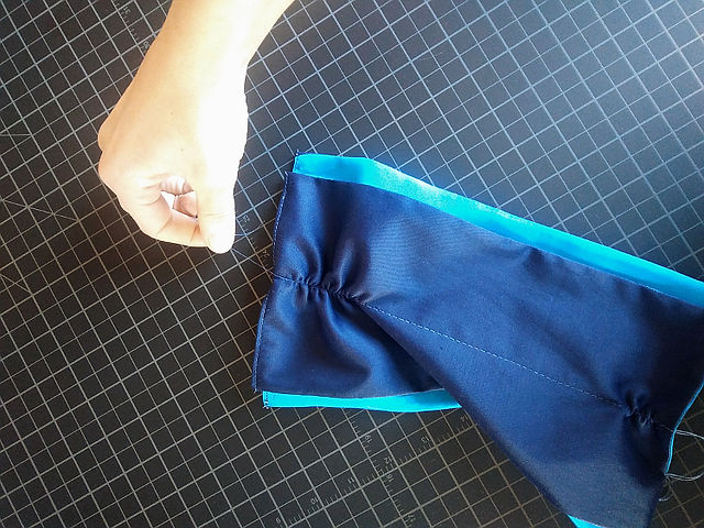 Pull on one of the two end threads from your center line stitch and work the fabric down into...a ruffle! When you gather it to the length of the front of your mule/shoe, stop and tie off the ends, so your gather stays in. Trim the excess thread.