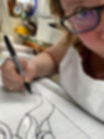Leia Powell using a Sharpie to darken the lines on "Light My Fire" pattern