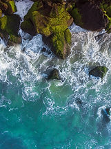 vertical-overhead-aerial-shot-wavy-blue-sea-against-rocks.jpg