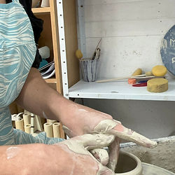 Michelle Foote sat at her Leach kick wheel throwing a pot