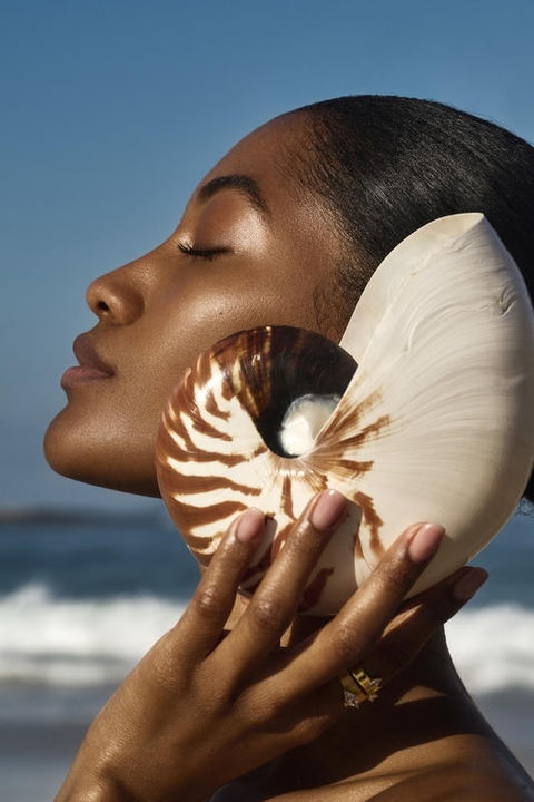 sun-kissed skin and seashell harmony by the ocean, radiant glow with coastal elegance.