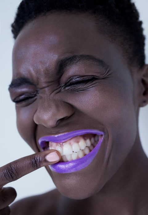 joyful beauty moment with vibrant purple lipstick and expressive natural radiance.