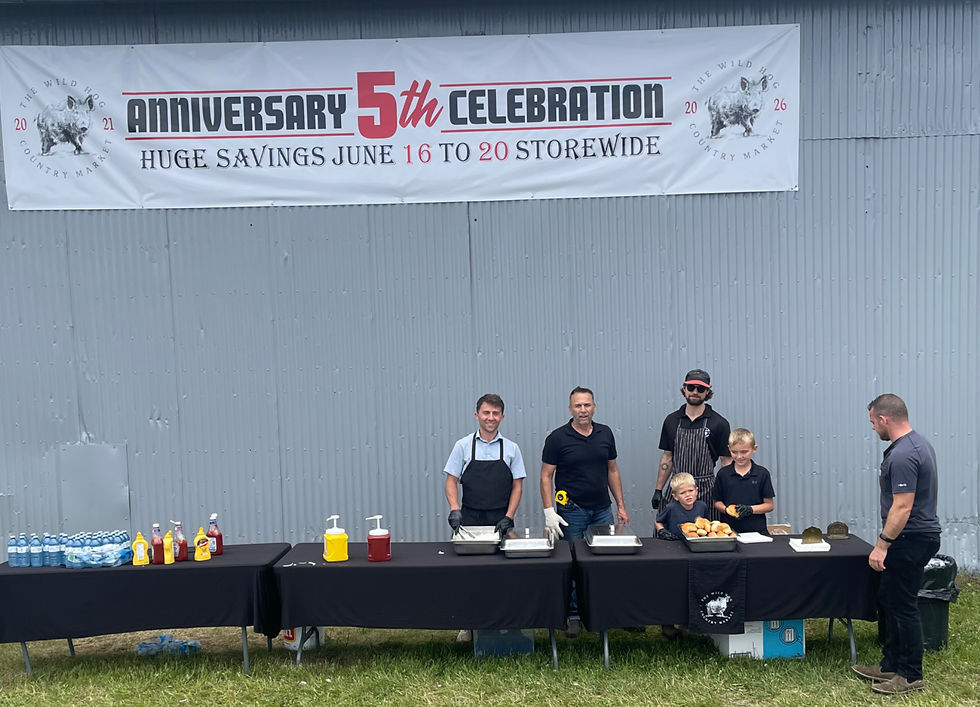 Marvin Bachert, second from left, joins members of the Wild Hog Country Market team as they serve hundreds of hamburgers and hot dogs during the market's fifth-anniversary celebration on Highway 7/8, east of Stratford. Gary West photo