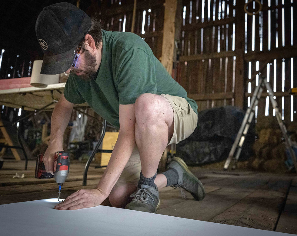 Volunteer Zach Brown works on attaching sign boards to stakes to hold signs for the upcoming Cultivate Festival.