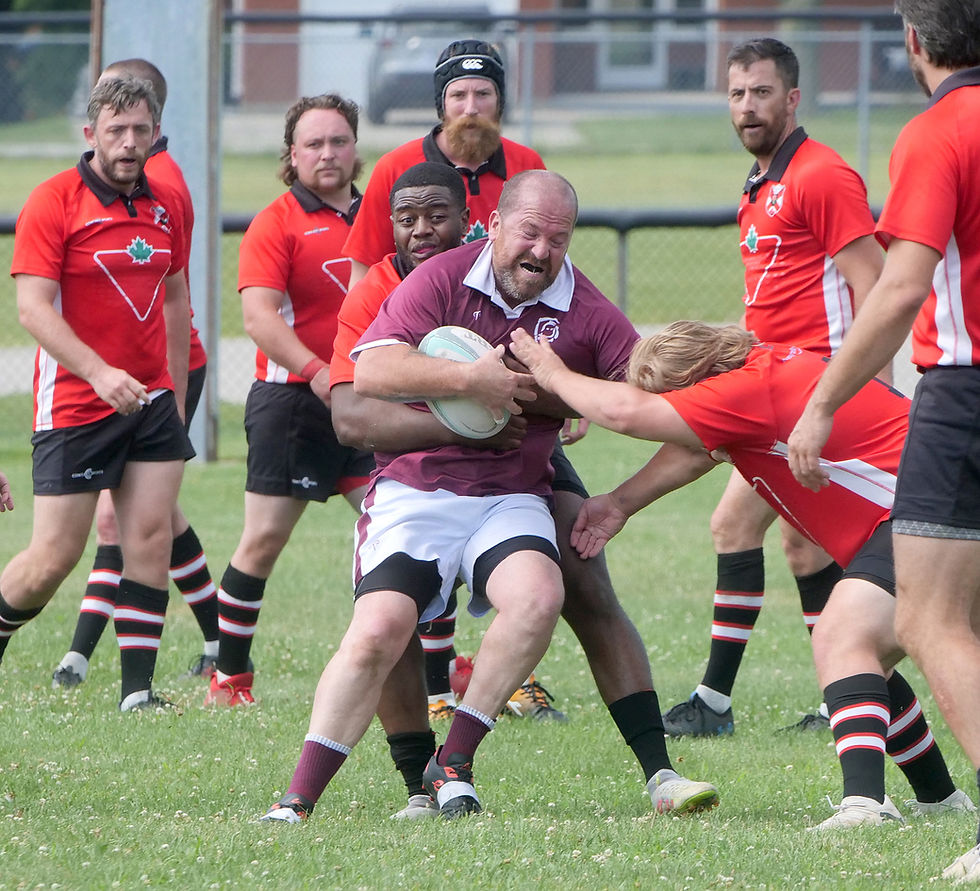 Norfolk Harvesters’ Jeff Butler is surrounded by Windsor players during a 2’s men’s rugby game Saturday in Waterford.