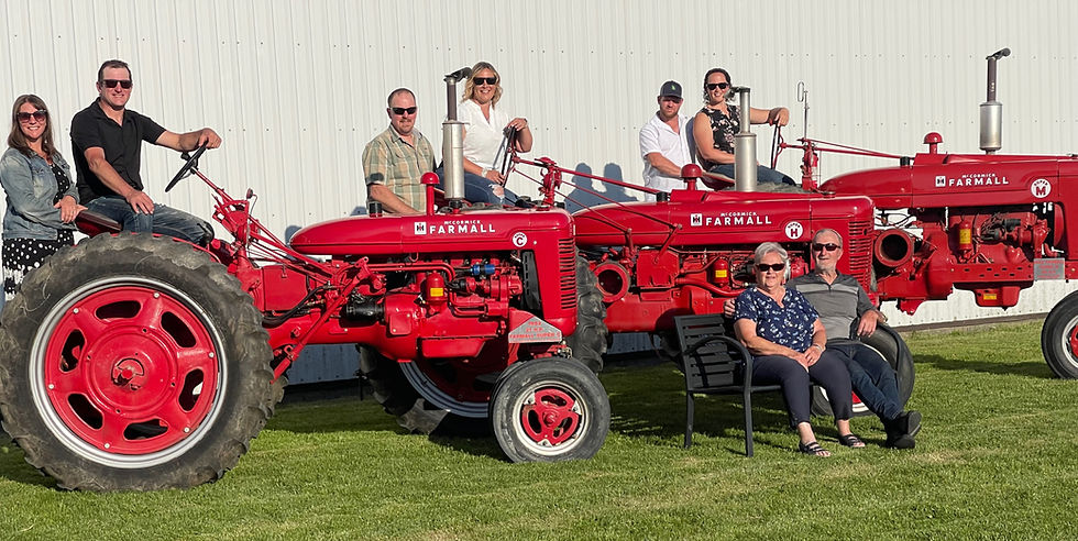Shirley and David Wilhelm sit in front of three International Harvester Farmall tractors they recently gifted to their children during a family celebration at the home farm on the Fifth Concession of North Easthope Township. Gary West photo