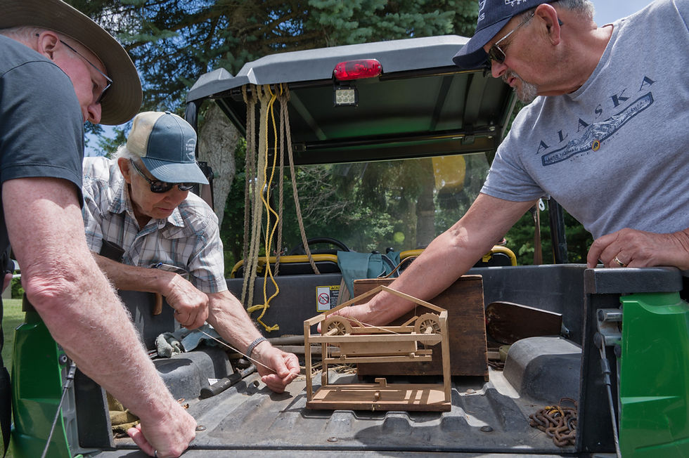 Dave Spiece (right) shows Hugh Fraser (left) and Jim Bucknall a family heirloom: an old model of a rack lifter made by his great grandfather. ~ Luke Edwards photo