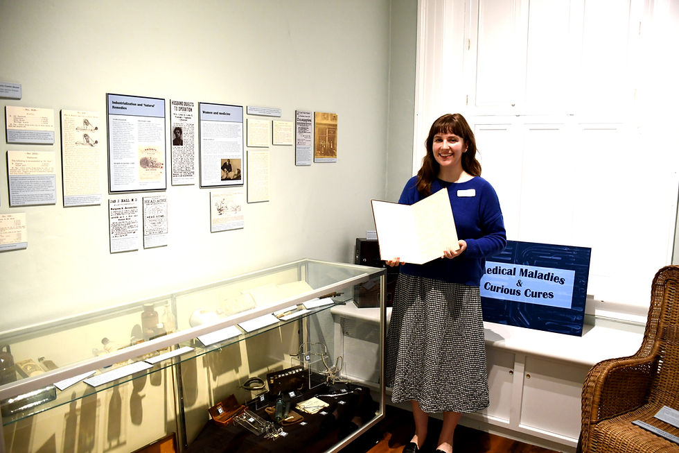 St. Marys Museum curator assistant Emily Taylor holds Dr. Benjamin Franklin Weaver’s 1907 book, Physical Charts Illustrating Pains Aches and Tender Spots, in one of the museum’s most unique exhibits, Medical Maladies and Curious Cures.