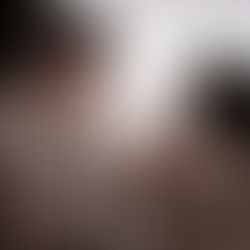 Genitori e fratellino che guardano la loro bimba neonata con amore durante un servizio fotografico in studio.